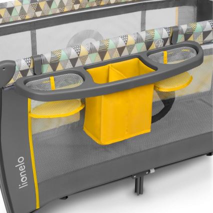 Postieľka s pripevneným organizérom na boku. Organizér má tri sieťované priehradky a jednu väčšiu látkovú v žltej farbe. Bočnica postieľky je sivá s geometrickým vzorom a značkou Lionelo.