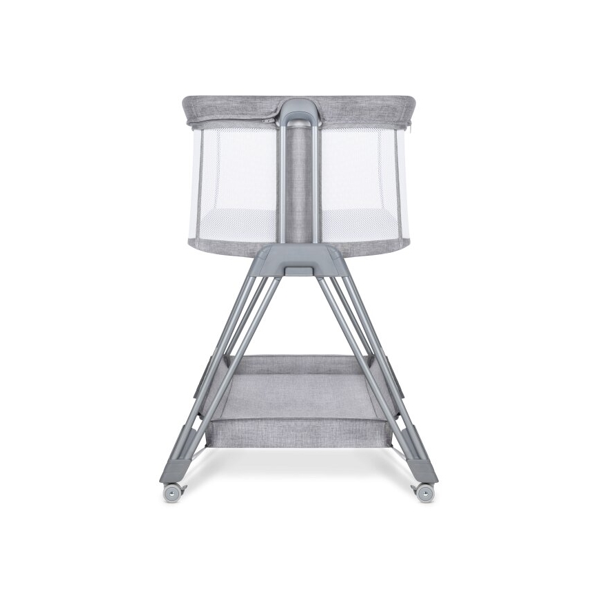 Detská postieľka stojí na kovovom stojane s kolieskami a spodnou poličkou. Postieľka má sivú látkovú časť a sieťované bočnice. Je zobrazená spredu.