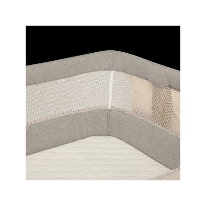 Postieľka s ochrannou mantinelovou vložkou sivých a bielych odtieňov s priedušnou sieťovinou. Vložka je položená na matraci.