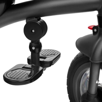 Detský trojkolkový bicykel; skladacia opierka nôh je zložená pod rámom; čierny plast a kolesá.