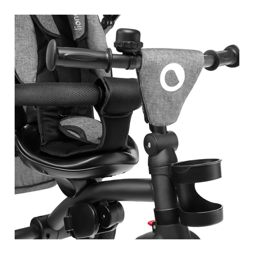 Trojkolka je zobrazená detailne, s dôrazom na sedadlo, riadidlá s zvončekom a držiakmi na nápoje. Je sivá a čierna.