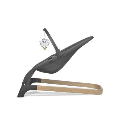 Detská hojdačka s tmavosivou textíliou a drevenými nohami je zobrazená zboku. K hojdačke je pripevnená hračka v tvare hviezdy na balón.