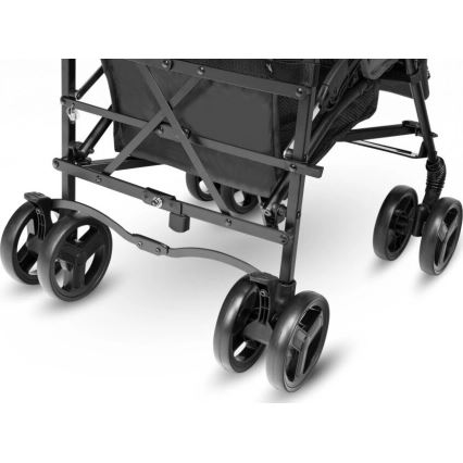 Skladací vozík stojí na štyroch pároch koliesok. Je vyrobený z kovu a má čiernu látkovú časť. Zobrazená je spodná časť s mechanizmom skladania a kolesami.