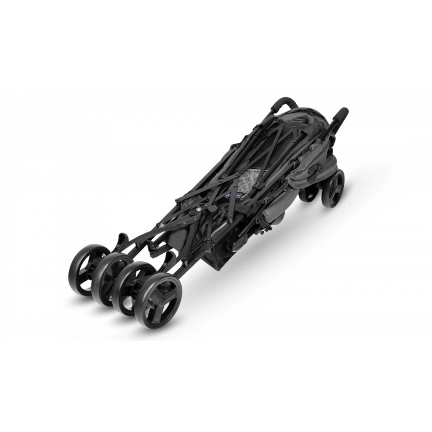 Detský kočík je zložený, stojí na štyroch kolieskach na bielom pozadí. Konštrukcia je tmavá, skladacia.