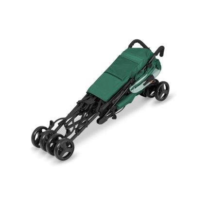 Zložený zelený kočík s čiernymi kolesami leží na bielom pozadí. Kočík je zložený do kompaktného tvaru, pripravený na prenášanie alebo uskladnenie.