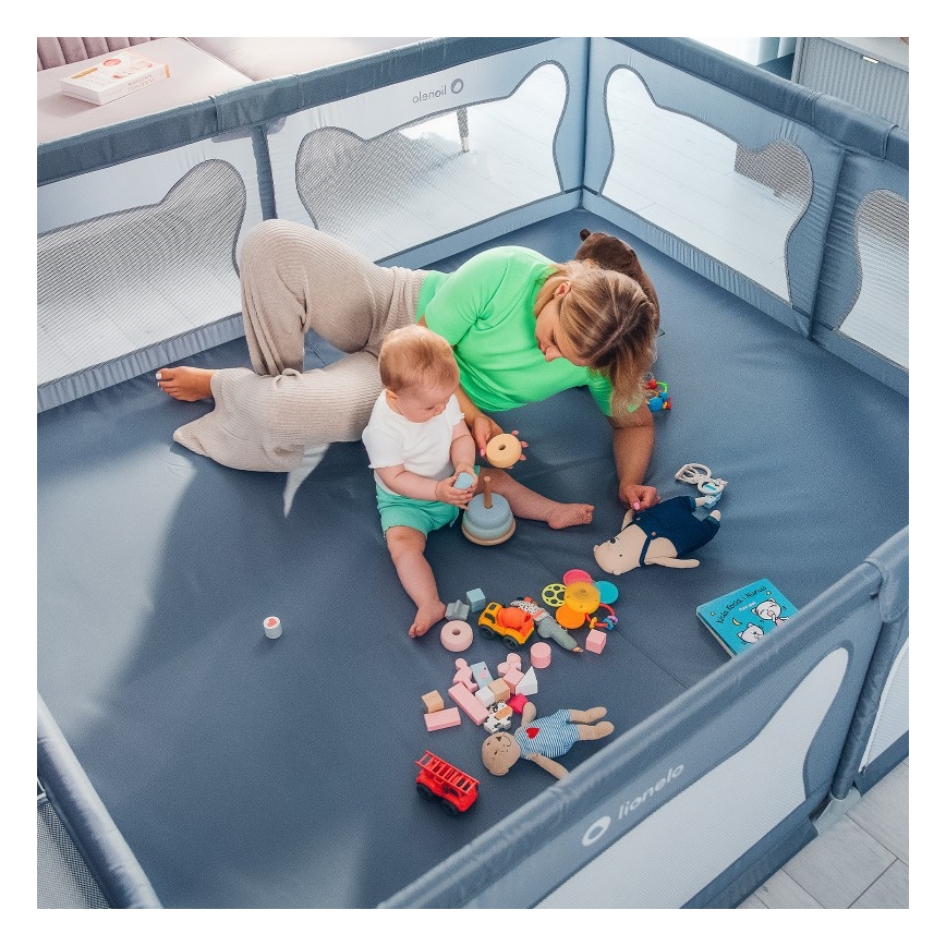 Bábätko s matkou sa hrajú s hračkami v ohrádke. Ohrádka je sivomodrej farby, na jej bočnici je logo Lionelo. Na podlahe ohrádky sú rôzne detské hračky, vrátane drevených kociek, plyšových hračiek a knižky.