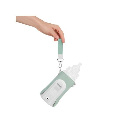 Ruka drží fľašku na mlieko v ochrannom púzdre Lionelo s popruhom. Púzdre má zabudovaný ohrievač. Na púzdre je viditeľné logo Lionelo.