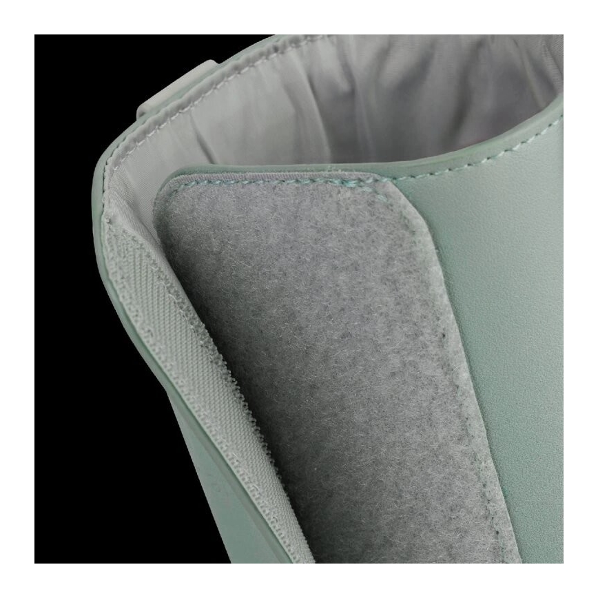 Vnútorná časť svetlomätovej čižmy ukazuje detail suchého zipsu na mäkkom, sivom materiáli pri vnútornom okraji. Čižma je z pevného materiálu, ktorý vytvára kontrast s vnútornou podšívkou.