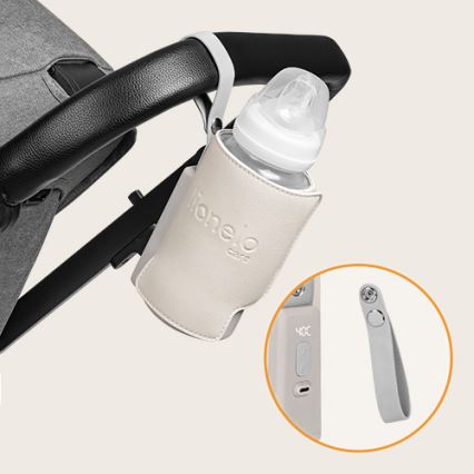 Plastová detská fľaša je pripevnená v béžovom puzdre na kočík. Puzdro má logo Lionelo Care. Súčasťou je aj odnímateľný popruh.