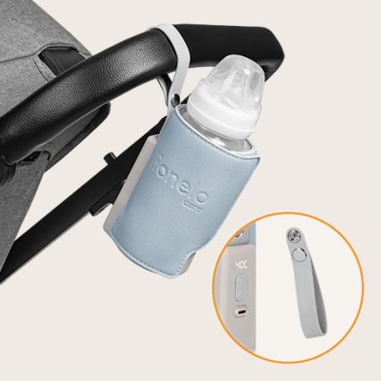 Fľaša s nápojom je pripevnená k detskej kočíkovej rúčke pomocou modrého puzdra. Puzdro má nápis lioneo care. Súčasťou je aj odnímateľný popruh.