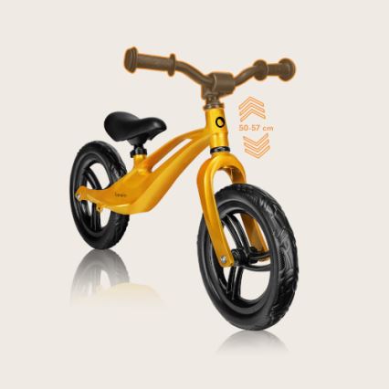 Zlatý odrážadlo stojí na svetlom pozadí. Je určené pre deti s výškou 50-57 cm. Má čiernu sedadlovku a pneumatiky.