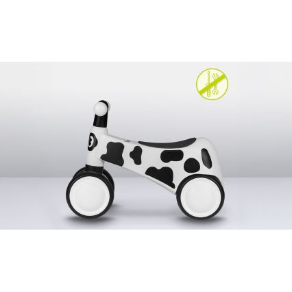 Detské odrážadlá v tvare kravy s bielym a čiernym vzorom stojí na svetlej podlahe. Je bez potreby montáže.