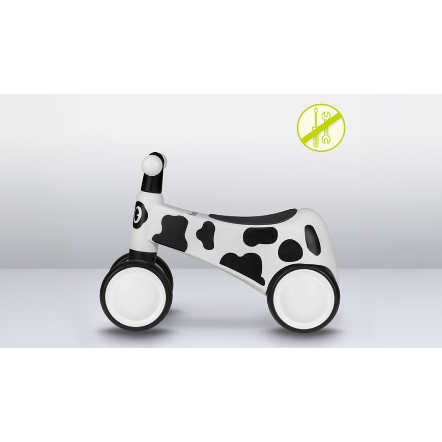 Detské odrážadlá v tvare kravy s bielym a čiernym vzorom stojí na svetlej podlahe. Je bez potreby montáže.