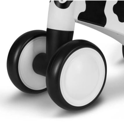 Chodítko s bielymi kolesami s čiernym okrajom a čiernobielym dizajnom v štýle kravy stojí na bielom povrchu.