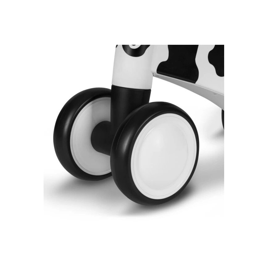 Chodítko s bielymi kolesami s čiernym okrajom a čiernobielym dizajnom v štýle kravy stojí na bielom povrchu.