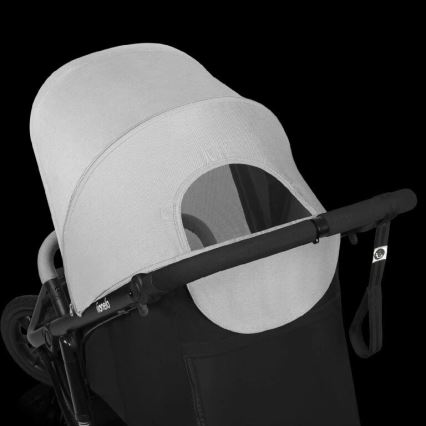 Športový kočík s šedou strieškou a čiernou konštrukciou. Strieška je čiastočne otvorená, odhaľujúc okienko. Kočík má čierne madlo. Na konštrukcii je viditeľné logo Joolz.