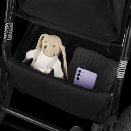 Kočík má odkladací priestor, v ktorom sa nachádza plyšová hračka a mobilný telefón. Odkladací priestor je súčasťou čierneho kočíka.