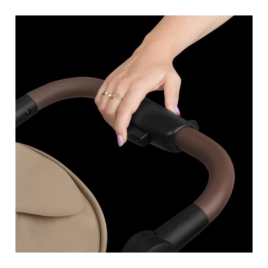 Ruka nastavuje výšku rúčky kočíka s hnedou koženkovou rukoväťou a čiernymi plastovými časťami. Kočík je béžovej farby.