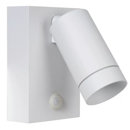 Biela nástenná lampa s valcovým tienidlom smeruje doprava. Lampa je pripevnená k štvorcovému podstavcu, na ktorom je zabudovaný pohybový senzor.