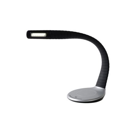 Stolová lampa s LED osvetlením svieti. Má ohnuté čierne rameno a striebornú základňu s bezdrôtovou nabíjacou plochou.
