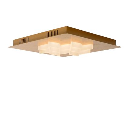 Stropné svietidlo svieti. Štvorcové zlaté telo svietidla obsahuje niekoľko mliečne bielych, kockovitých svetelných prvkov. Svietidlo je umiestnené na bielom pozadí.