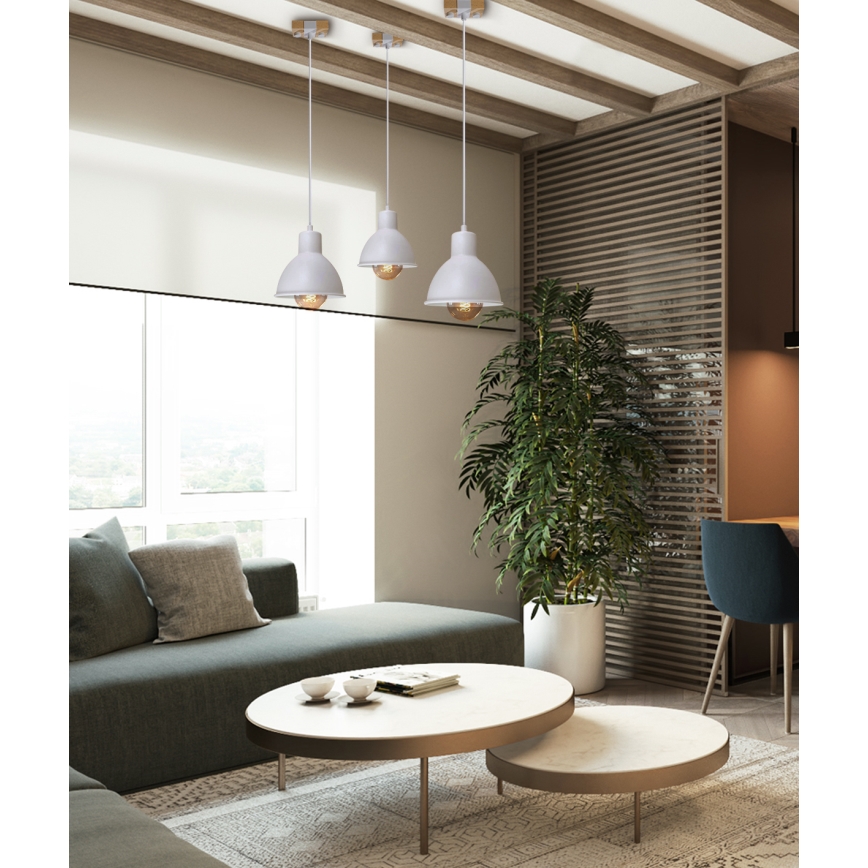 Tri visiace sivé lampy s presklenými žiarovkami svietia v obývacej izbe s pohovkou, kávovým stolíkom a izbovou rastlinou.