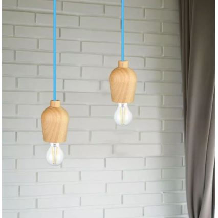 Dve drevené závesné lampy s textilnými káblami svetlomodrej farby visia pred bielou tehlovou stenou. Lampy obsahujú žiarovky.