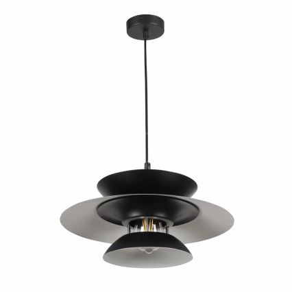 Čierna závesná lampa s tromi tienidlami, visí zo stropu. Najväčšie tienidlo je svetlosivé, pod ním sú dva menšie čierne tienidlá. Vnútorné tienidlo odhaľuje žiarovku.