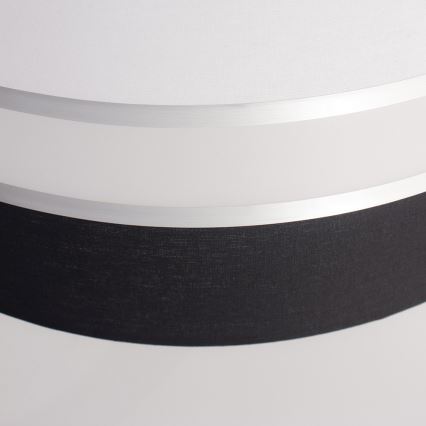 Dvojvrstvový tienidlo svietidla, zložené z bieleho a čierneho textilného materiálu, je oddelené úzkym strieborným pásom. Biely vrchný diel je hladký, spodný čierny je textúrovaný.