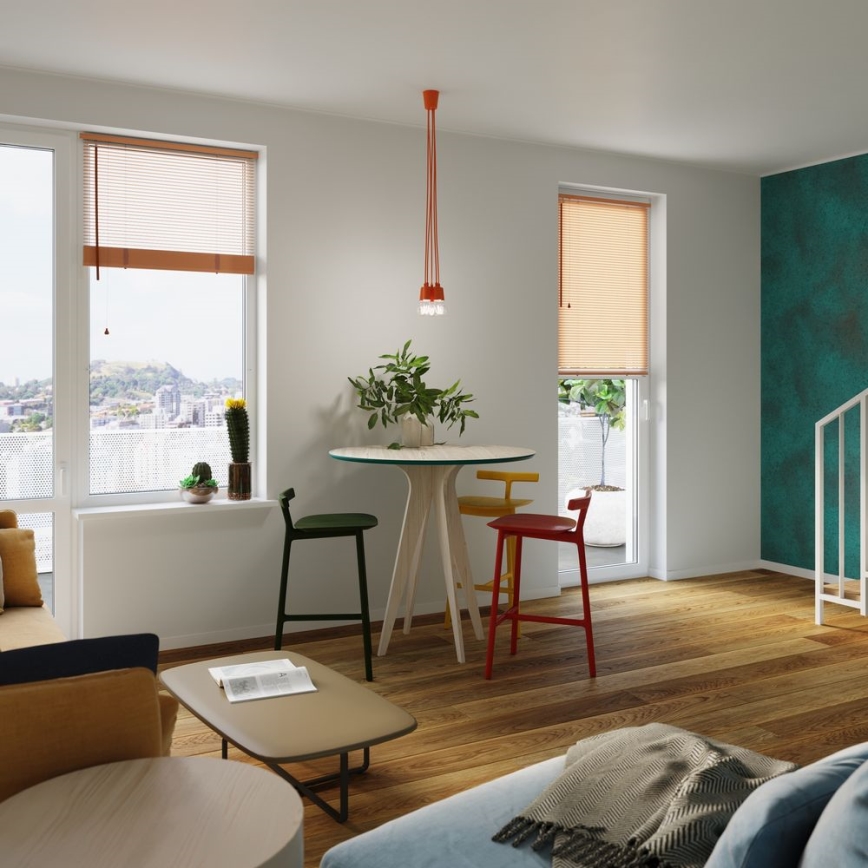 Jedálenský stôl so štyrmi stoličkami stojí v svetlej izbe s drevenou podlahou. Nad stolom visí stropné svietidlo. Okná sú vybavené žalúziami.