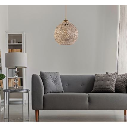 Plavicové guľové svietidlo visí nad sivou sedačkou v obývacej izbe. Sedačka má dekoračné vankúše. V pozadí je vidieť knižnicu a stolík.