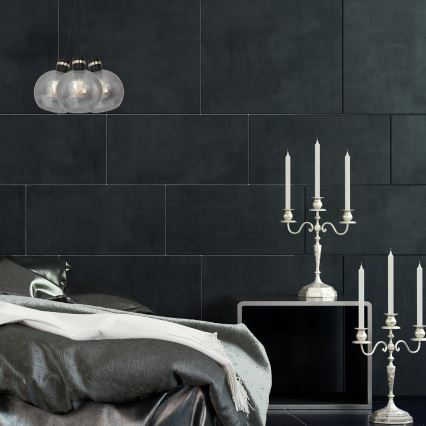 Trojramenné svietidlo visí v spálni. Na nočnom stolíku stoja dva strieborné kandelábre s horiacimi sviečkami. Steny sú tmavosivé, obložené dlaždicami.