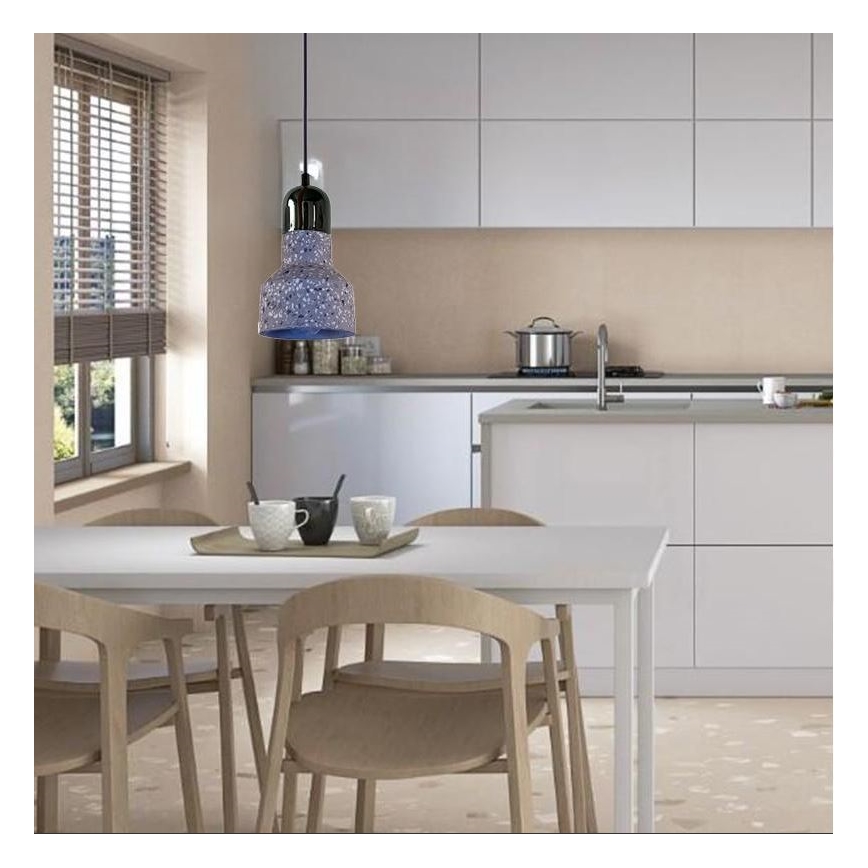 Zavesené svietidlo svieti nad jedálenským stolom. Svietidlo má sivý tienidlo s tmavosivou kovovou konštrukciou. Nachádza sa v svetlej kuchyni s bielym nábytkom a drevenými stoličkami.