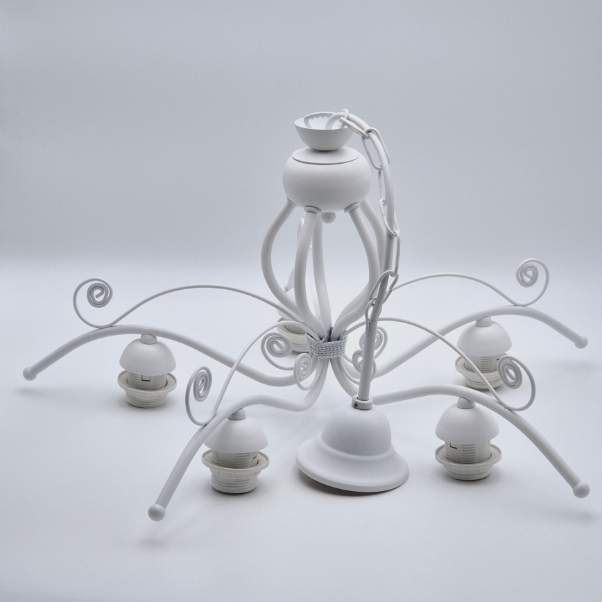 Biela kovová luster s piatimi ramenami visí. Rameno sú ozdobené ornamentami. Luster je umiestnený na bielom pozadí.