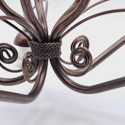 Medený stropný kryt s mierne nerovným povrchom je pripevnený k kovovej tyči. Kryt je zvrchu otvorený a má tvar zvona.