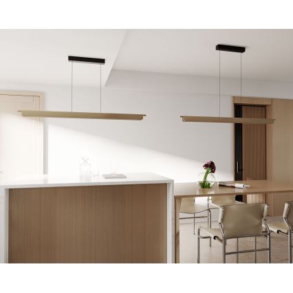 Dve dlhé, obdĺžnikové svietidlá visia zo stropu nad kuchynským ostrovčekom a jedálenským stolom v moderne zariadenej miestnosti. Svietidlá sú drevené s čiernym kovovým držiakom.