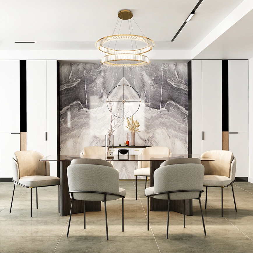 Dvojité kruhové lustre visí nad jedálenským stolom s ôsmimi stoličkami v moderne zariadenej jedálni s mramorovou stenou.