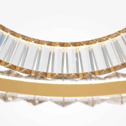 Krištáľové svietidlo s dvojitým okrúhlym rámom, osvetlené LED diódami, je zavesené. Vnútorný a vonkajší okraj zdobia zvislé hranolovité krištáľové prvky, osadené do zlatej kovovej konštrukcie.