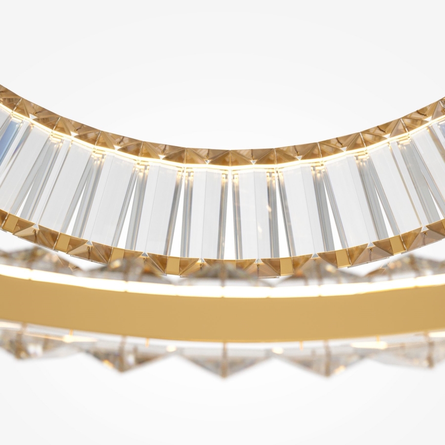 Krištáľové svietidlo s dvojitým okrúhlym rámom, osvetlené LED diódami, je zavesené. Vnútorný a vonkajší okraj zdobia zvislé hranolovité krištáľové prvky, osadené do zlatej kovovej konštrukcie.