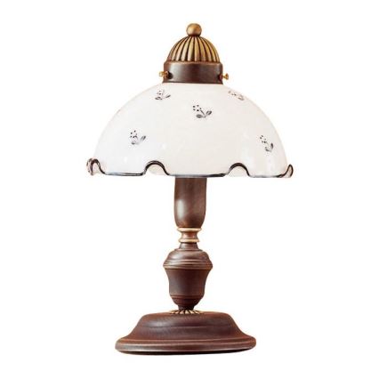 Stolová lampa s bielym tienidlom zdobeným drobnými kvietkami svieti. Tienidlo je zvlnené na okraji a má hnedý drevený podstavec. Lampa je umiestnená na bielom pozadí.