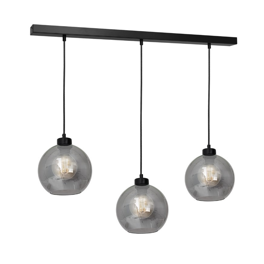 Trojramenné závesné svietidlo s čiernou konštrukciou a tromi šedými sklenenými guľovými tienidlami visí zo stropu. Každé tienidlo obsahuje žiarovku.