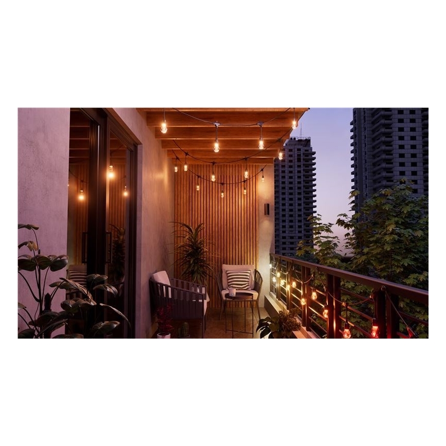 Balkónový nábytok s osvetlením. Svietia elektrické girlandy. Kontext: mestské prostredie, vysoké budovy.