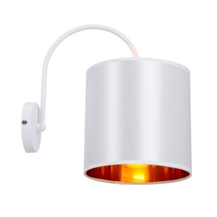 Biela nástenná lampa s krivolakým ramenom a valcovým tienidlom. Tienidlo je zvonku biele, vnútri medené, svieti. Lampa je pripevnená k stene.