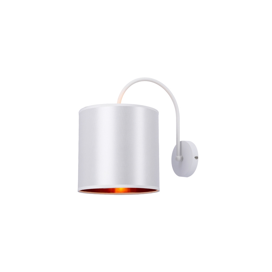 Biela nástenná lampa s valcovým tienidlom a vnútorným medeným lemom svieti. Lampa je pripevnená k stene ohnutou bielou konzolou.