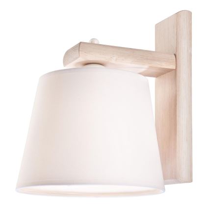 Nástenná lampa s bielym tienidlom je pripevnená na betónovej stene. Lampa je umiestnená vedľa izbovej rastliny v kvetináči a radiátora. Okná s výhľadom na zelenú krajinu sú v pozadí.
