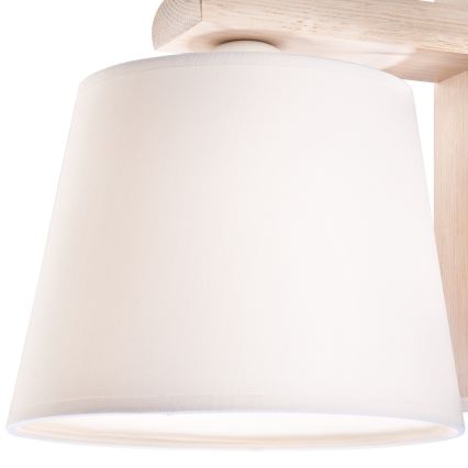 Drevená stropná lampa s bielym tienidlom je pripevnená k stropu. Lampa je z ľahkého dreva, tienidlo je látkové.