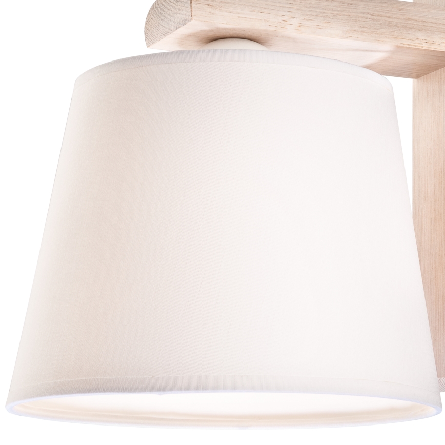 Drevená stropná lampa s bielym tienidlom je pripevnená k stropu. Lampa je z ľahkého dreva, tienidlo je látkové.