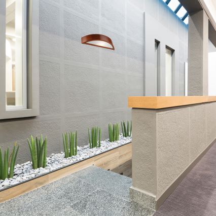 Drevené svietidlo v tvare oblúka s matným skleneným difúzorom. Svietidlo je hnedo-oranžovej farby. Je umiestnené na bielom pozadí.