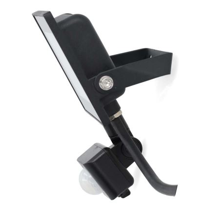 Čierny LED reflektor s pohybovým senzorom je pripevnený na stene. Svietidlo je natočené doprava, senzor smeruje dole.