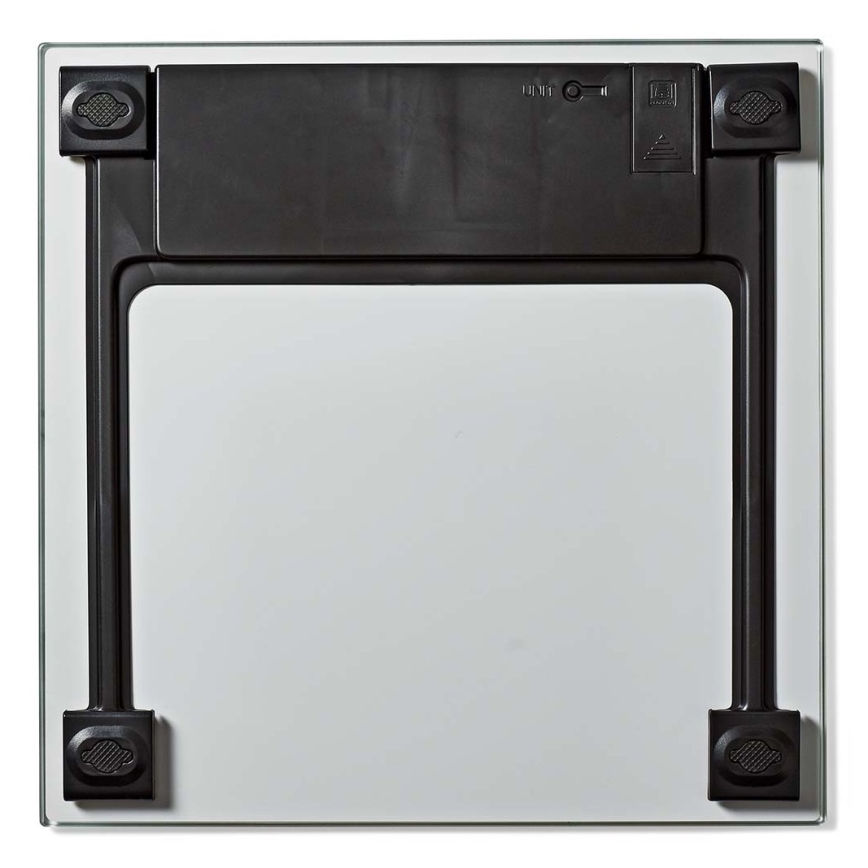 Váha z bezpečnostného skla leží na bielom pozadí. Na zadnej strane je viditeľný čierny mechanizmus s vypínačom. Na okrajoch sú umiestnené protišmykové nožičky.